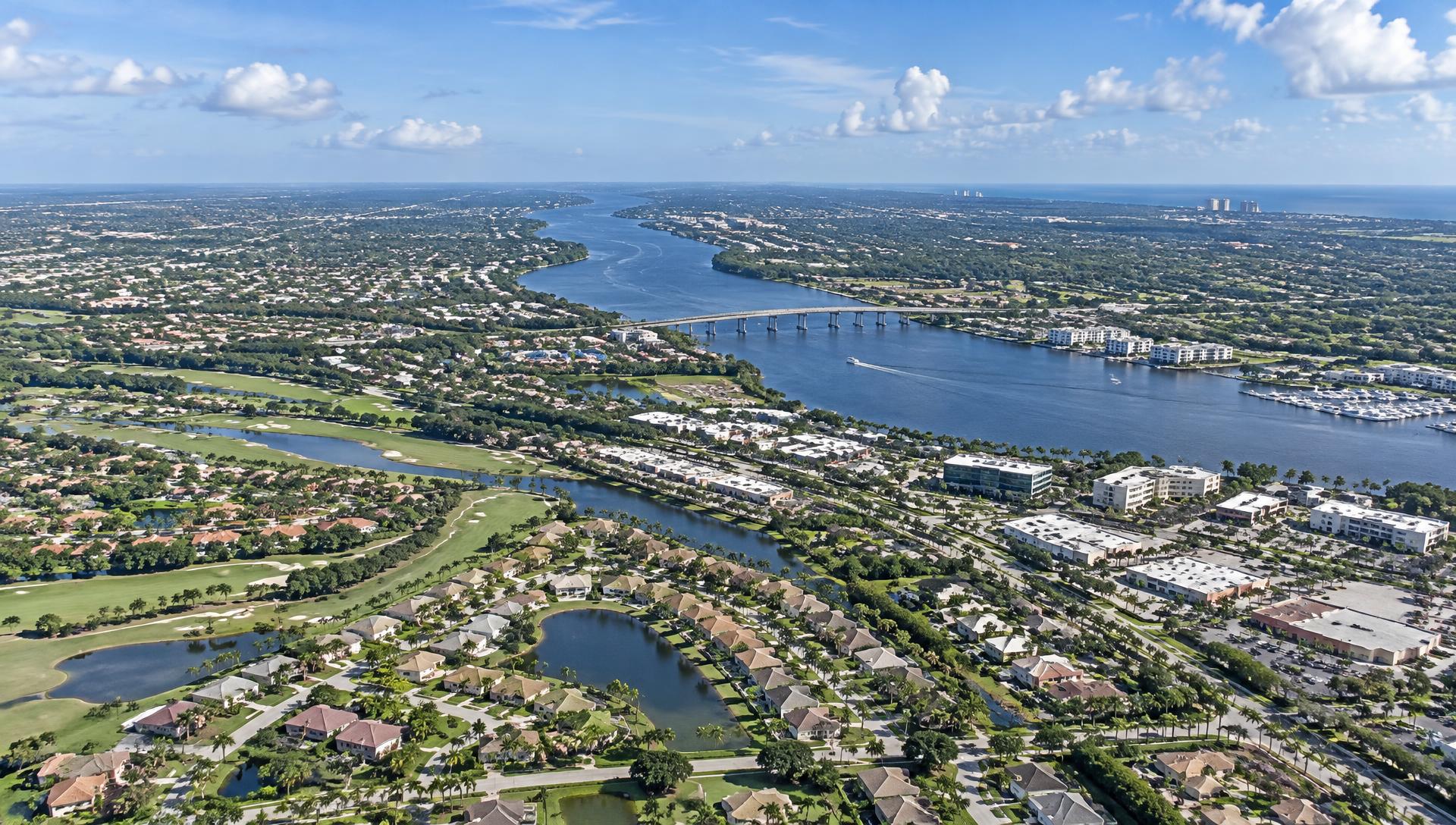 Sweeping aerial view of Port St. Lucie, Florida with the St. Lucie River, golf courses and commercial corridors