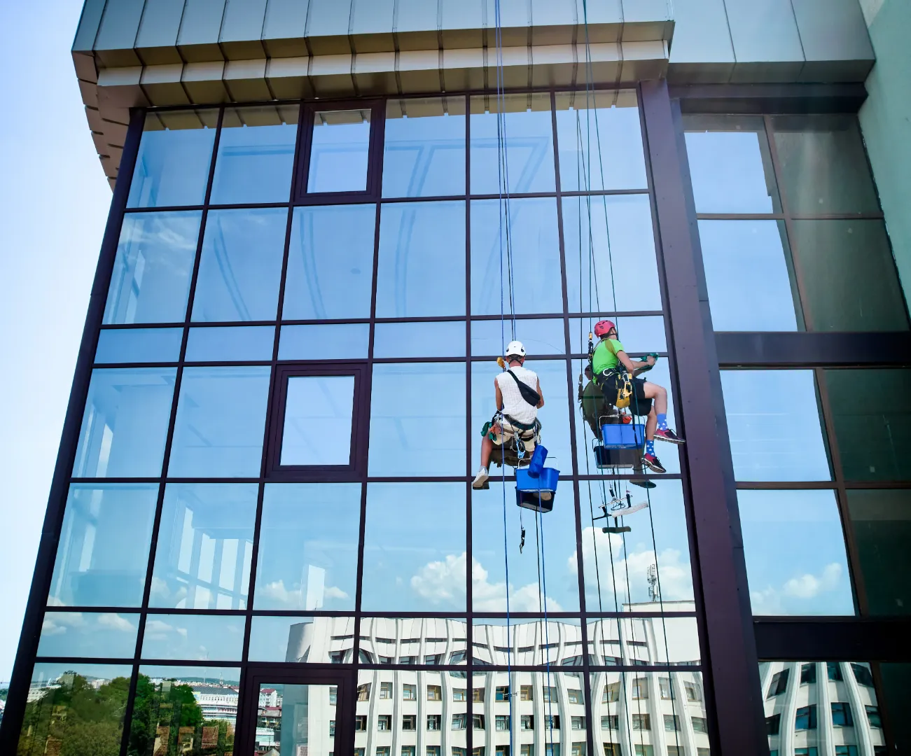 Professional window cleaners working on a multi-story office building