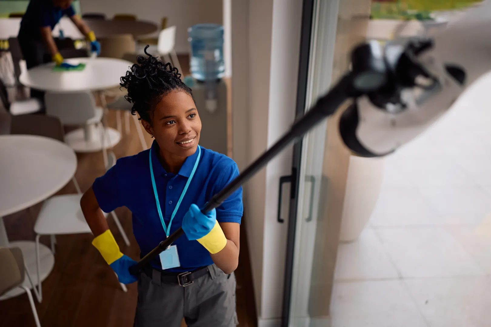 Cleaner washing a restaurant window with professional equipment