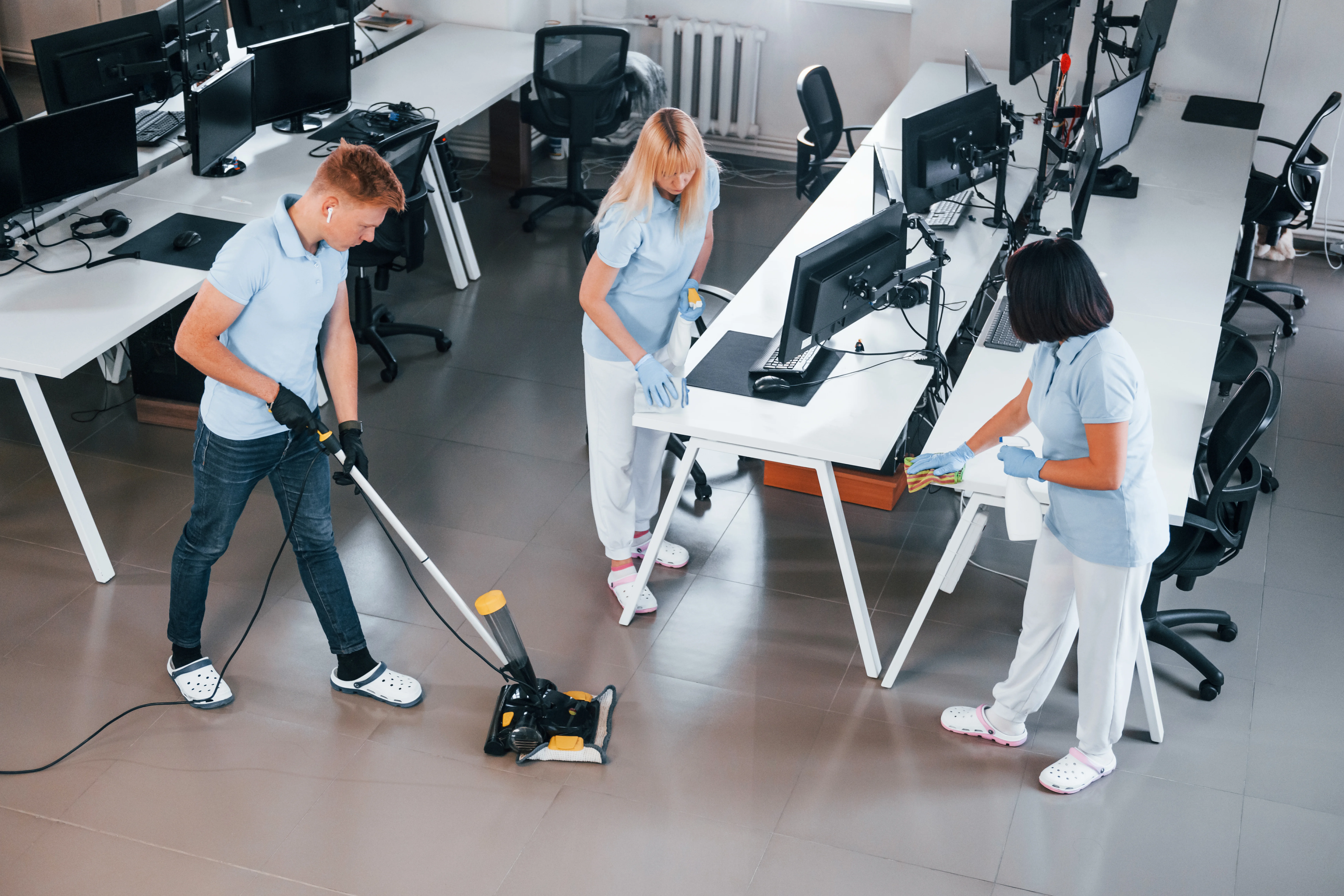 Commercial cleaning team vacuuming and cleaning an office workspace