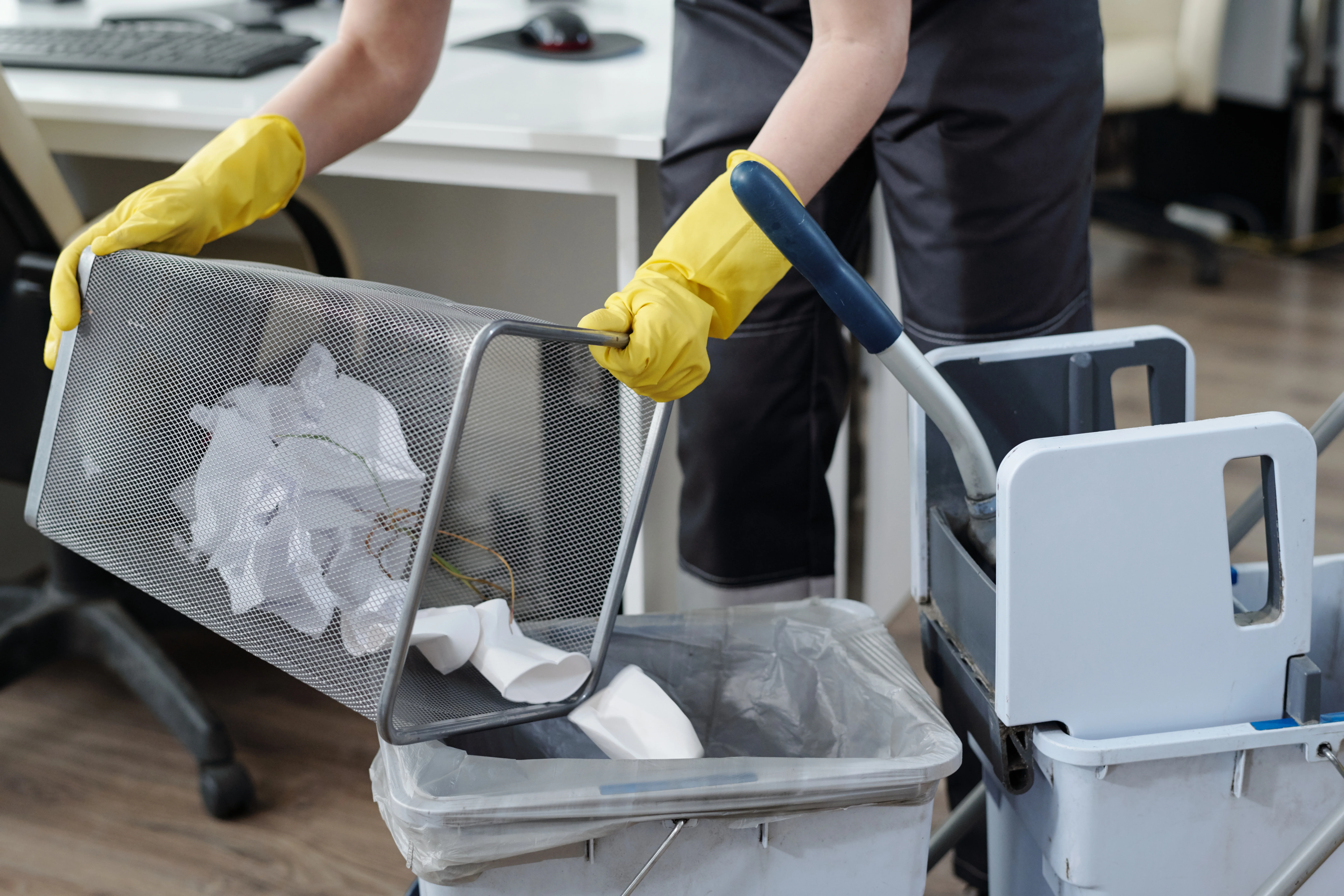 Commercial cleaner emptying office trash bins and replacing liners
