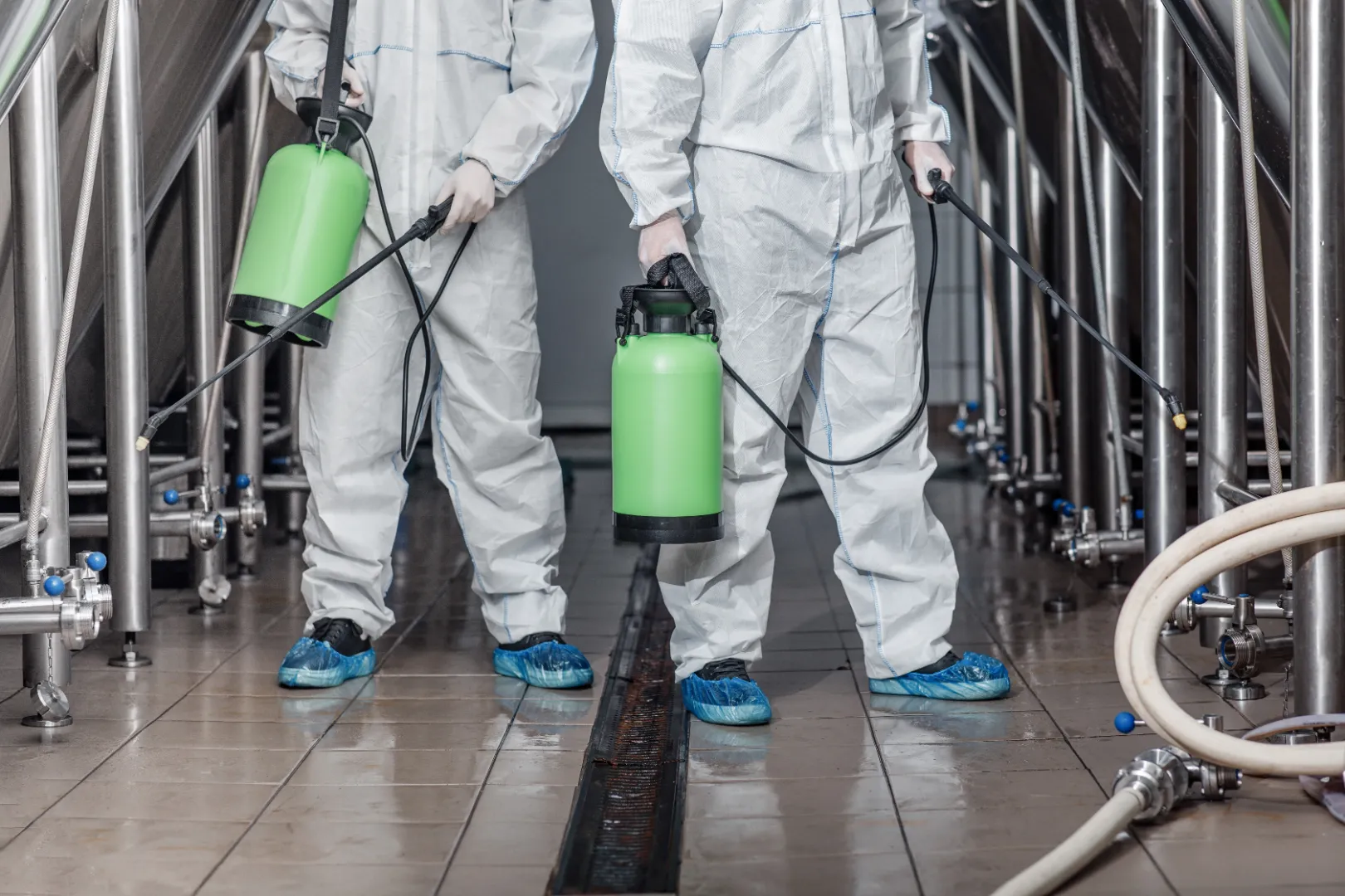 Workers cleaning surfaces inside an industrial facility