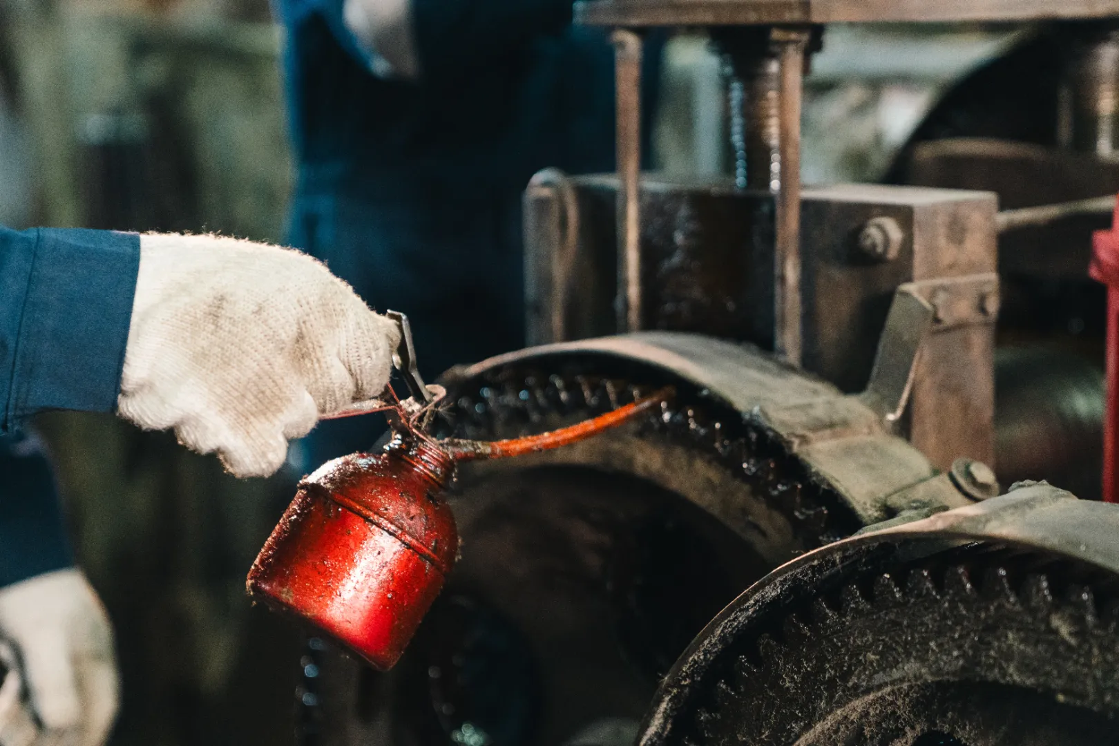 Worker removing grease from industrial machinery